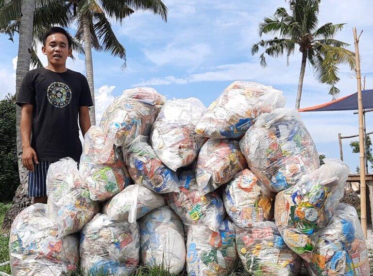a man standing next to a pile of plastic bags